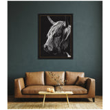Black and white framed portrait of a Scottish Highland cow with long shaggy hair and horns against a dark background, hanging above a tan leather sofa.