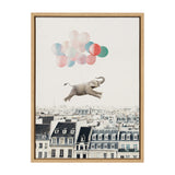 Surreal canvas art showing a gray elephant held aloft by pastel-colored balloons floating over Parisian rooftops under a pale sky, framed in light wood.