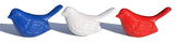 Three ceramic bird figurines in blue, white, and red, each with textured feather details and a smooth, glossy finish, aligned side by side against a white background.