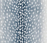 Close-up of navy blue pillow cover fabric with a pattern resembling white antelope spots scattered symmetrically across the surface.