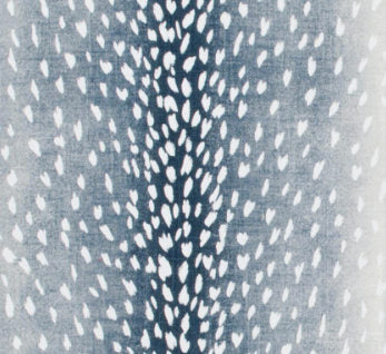 Close-up of navy blue pillow cover fabric with a pattern resembling white antelope spots scattered symmetrically across the surface.