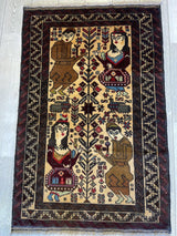 Rectangular Baluchi rug with two pairs of stylized human figures facing a tree, framed by intricate dark geometric borders on a light brown field.
