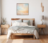 Minimalist bedroom with wooden platform bed, neutral bedding, matching wooden nightstands, soft pastel abstract canvas centered above the headboard, and natural light.