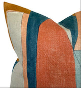 Close-up of District Pillow Cover showing geometric blocks in apricot, teal, mustard, blush, and cream colors with textured fabric.