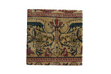 Decorative cork board featuring antique Kerman rug fragment with butterfly stylized relief and partial Serpent border, approx. 10 x 10 inches.