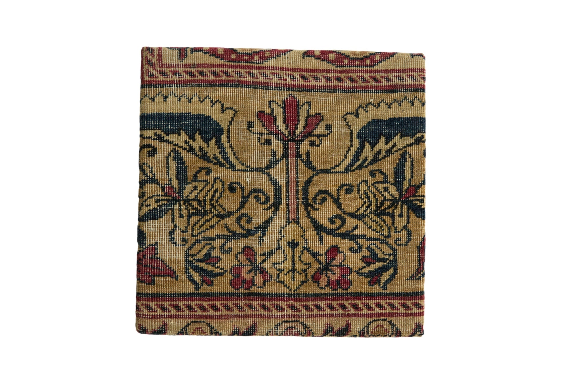 Decorative cork board featuring antique Kerman rug fragment with butterfly stylized relief and partial Serpent border, approx. 10 x 10 inches.