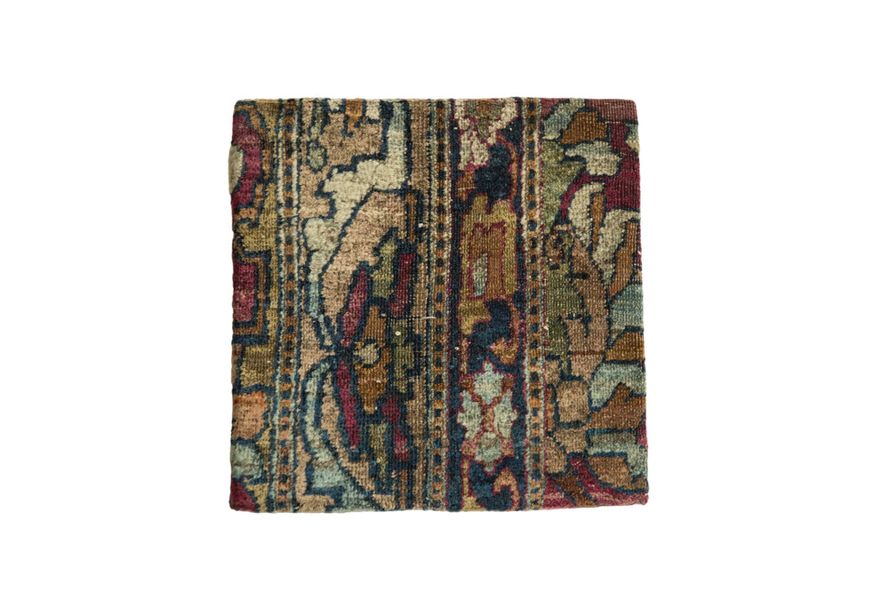 Decorative cork board featuring an antique Kerman rug fragment with rich floral patterns in warm reds and blues, framed and set as wall art