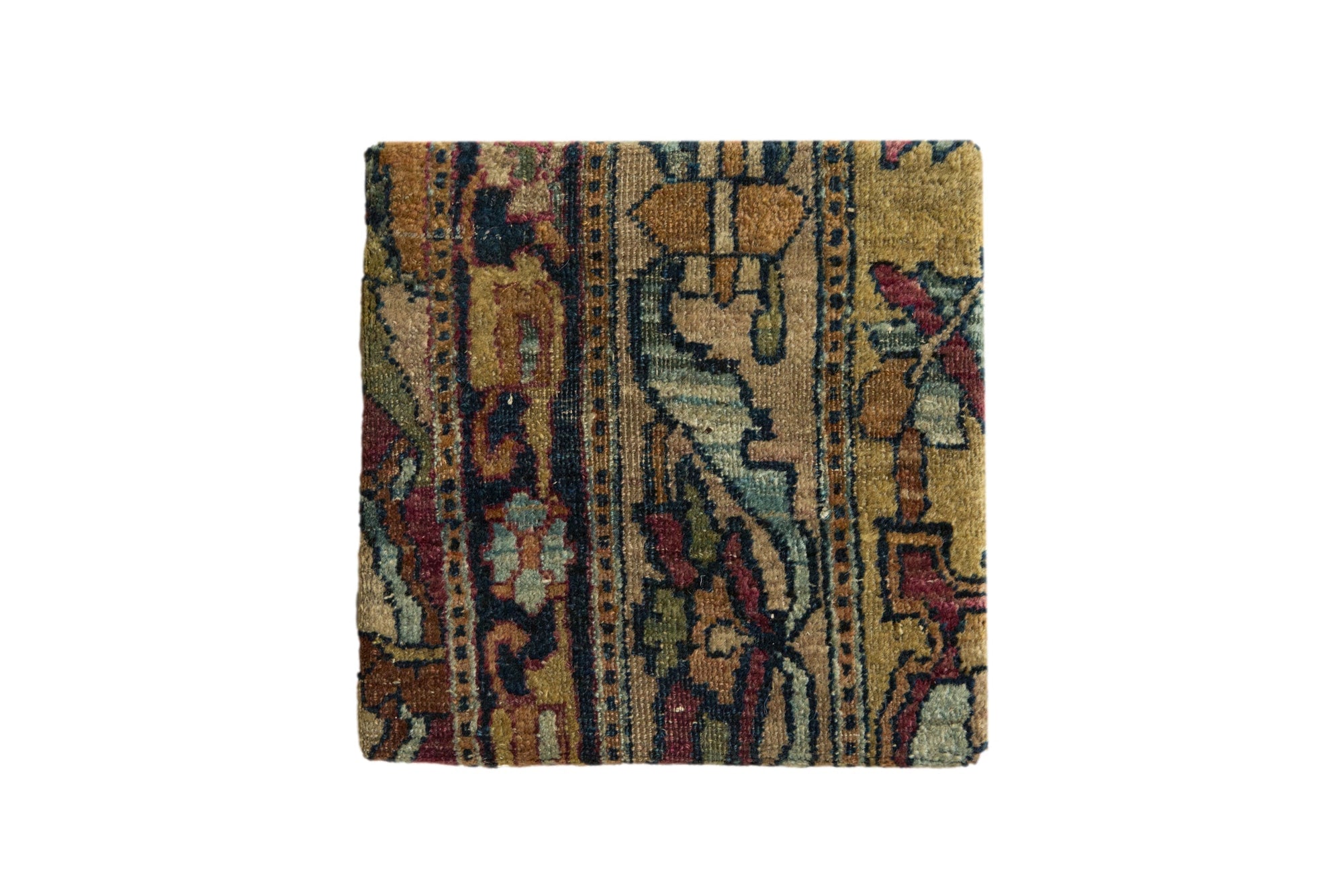 Decorative cork board featuring an antique Kerman rug fragment with intricate patterns and warm tones