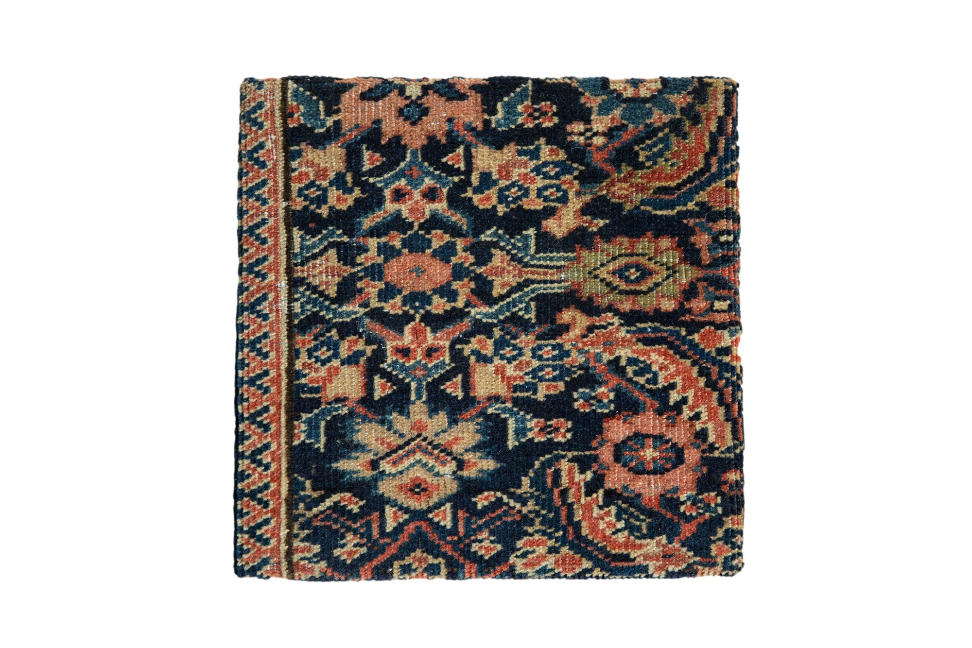 Decorative cork board featuring an antique Fereghan rug fragment with navy blue, ivory, red, rose, and green shades