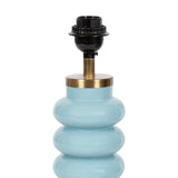 Curvy blue glass table lamp base with a brass collar and black bulb socket on top, shown against a white background.