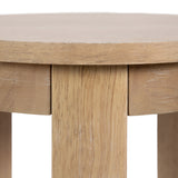Close-up of a round wood side table's smooth, light natural wood grain surface and straight, sturdy legs with visible wood texture and subtle finish variation.