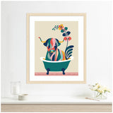 Colorful abstract cow with geometric shapes and floral elements sitting in a dark teal clawfoot bathtub against a beige background, framed in light wood.