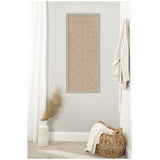 Vertical rectangular beige cork pinboard with white lattice pattern framed in light wood, hanging on light gray wall above carpeted floor with woven basket and vase.