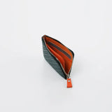 Small rectangular coin purse with dark green and white herringbone pattern exterior and bright orange interior, partially unzipped showing card slots.