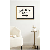 Framed canvas wall art with handwritten black text "DRAMATIC EXIT" and right arrow on white background above two white armchairs and a small round brass table with a white vase.