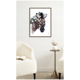 Framed canvas art print of a stylized zebra head adorned with blue and white flowers, displayed on a white wall between two white upholstered chairs with a small round side table.