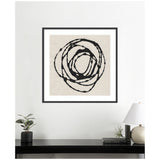Framed abstract art with concentric, irregular black circles on a beige textured background, hung above a black console holding a potted plant, books, and a white lamp.
