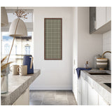 Tall vertical sage green fabric pinboard with a white plaid pattern in a wooden frame, mounted on a bright kitchen wall between concrete-style countertops.