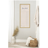 Tall rectangular pinboard with linen fabric printed as a vintage guest check, framed in light wood and hung on a beige wall beside white curtains and a basket.