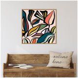Colorful abstract foliage with bold black outlines on pale pink background, framed and hung above a wooden bench with a beige 'welcome home' pillow and open book.