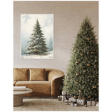 Living room with a large decorated evergreen Christmas tree beside a brown curved sofa, and a framed canvas of a snow-covered fir tree hanging on the wall.