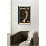 Framed vintage-style poster of an ostrich wearing glasses and smoking a pipe with the word 'PROSECCO' in large letters on a black background, hanging above a dark green armchair with a white knitted throw.