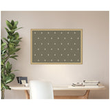 Rectangular green pinboard with small white botanical block print patterns, framed in light wood, hanging above a modern desk with white chair and a tall leafy plant nearby.