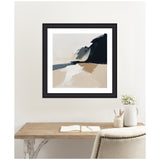 Abstract coastal landscape painting with soft beige sands, a dark cliff silhouette, and misty sky framed in black and displayed above a wooden desk with decorative vases.