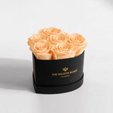 Black box containing a heart-shaped arrangement of six peach roses