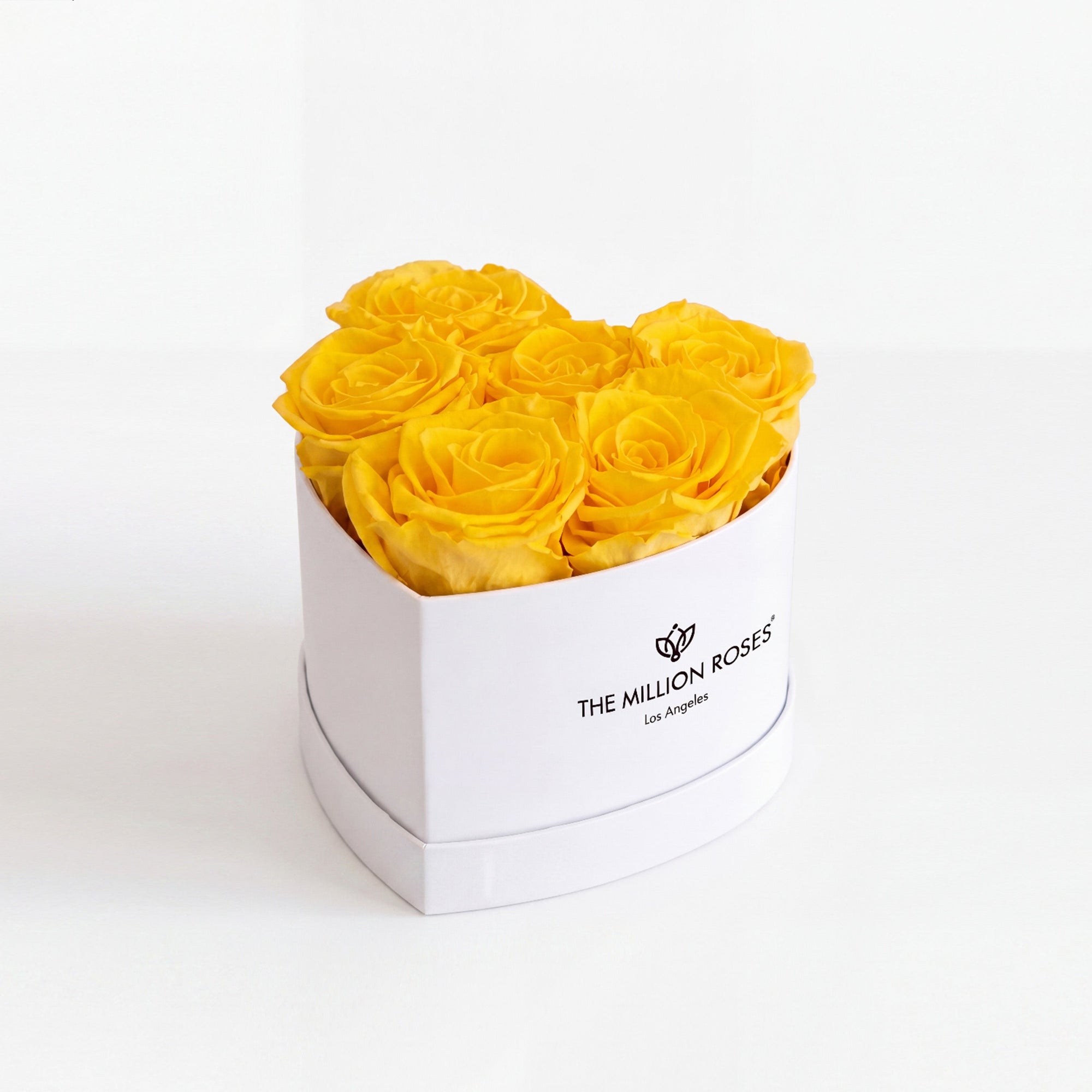 White box containing six yellow roses arranged in a heart shape