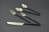 Five-piece stainless steel flatware set with twisted black swirl handles, including a knife, two forks, and two spoons, displayed on a dark gray background.