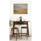 Framed impressionist landscape painting of Yalta with muted earth tones, hung above dark wood bar table and two matching stools with sleek silhouettes.