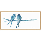 Two blue watercolor birds with white botanical patterns perched on a matching blue branch, framed in light wood, against a white background.