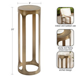 Tall, narrow metal side table with an antique brass finish, featuring an open arched design and a smooth cylindrical top, 23 inches high and 8 inches wide.