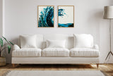 Two framed abstract canvases above a white sofa; paintings feature swirling deep teal and aqua blue waves with splatter effects on a white background.