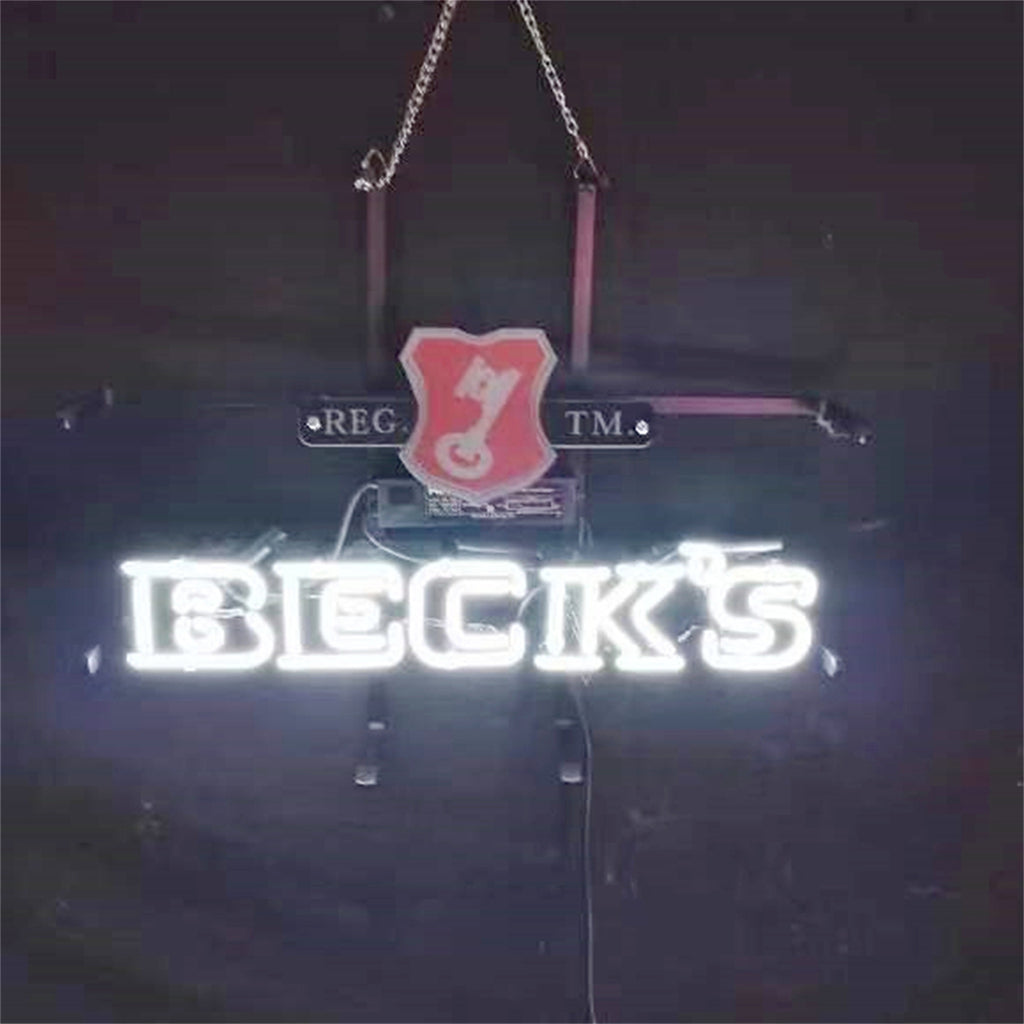 Illuminated neon sign displaying 'BECK'S' in white letters with a red key emblem above, mounted on a black metal frame and hanging by chains against a dark background.