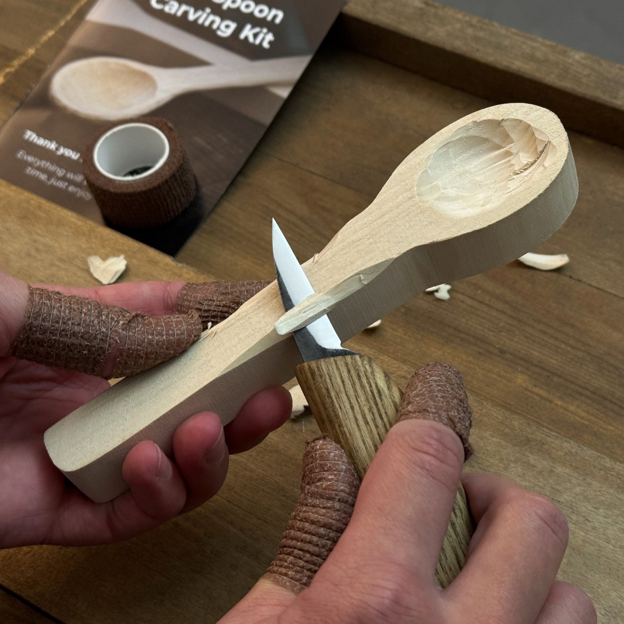 Beginner DIY Spoon Carving Kit with hand-forged knives, linden wood blanks, and carving tools laid out