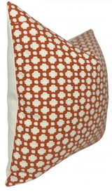 Rectangular pillow cover with a repeating rust-orange geometric pattern on a white background, shown from an angled side view
