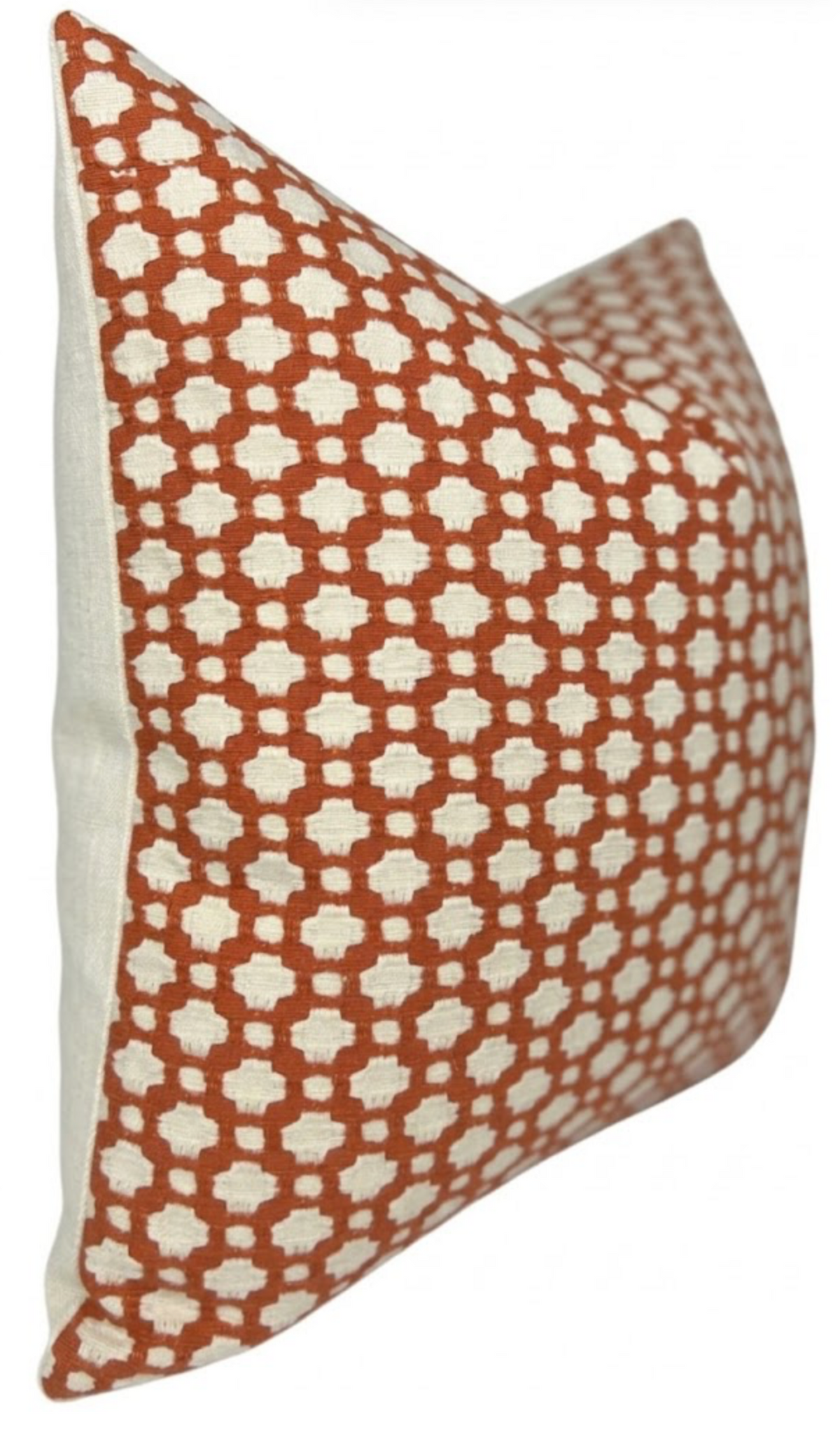 Rectangular pillow cover with a repeating rust-orange geometric pattern on a white background, shown from an angled side view