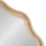 Close-up of a round mirror with a wooden scalloped frame featuring a natural light wood grain finish and gently curved edges.