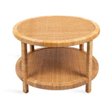 Round two-tier coffee table made from natural rattan with a woven textured surface and cylindrical legs connecting top and bottom shelves.