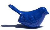 Smooth glossy blue bird figurine with a rounded body and raised feather patterns casting a shadow on a white background
