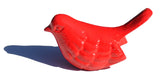 Glossy red bird figurine with smooth contours and subtle feather detailing casting a shadow on white background.