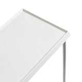 Close-up of a white rectangular slim side table with a subtle textured surface and thin metal legs, shown at an angled top corner view.