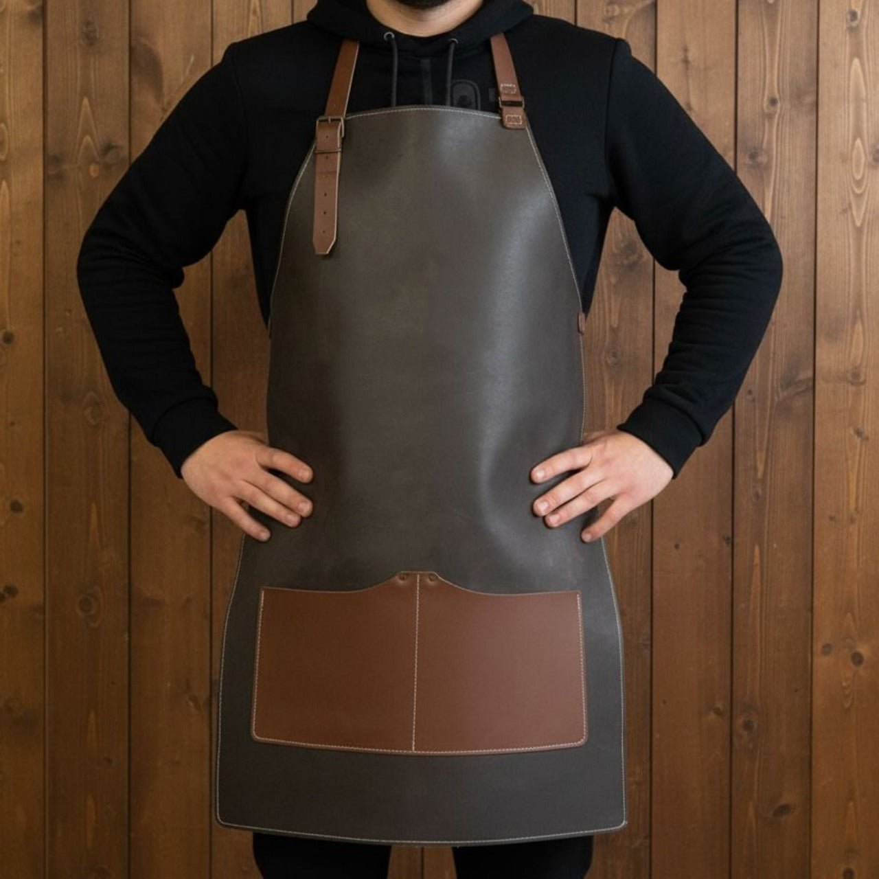Black leather work apron with adjustable straps and large front pockets