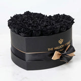 Black heart-shaped box filled with tightly arranged black roses from The Million Roses