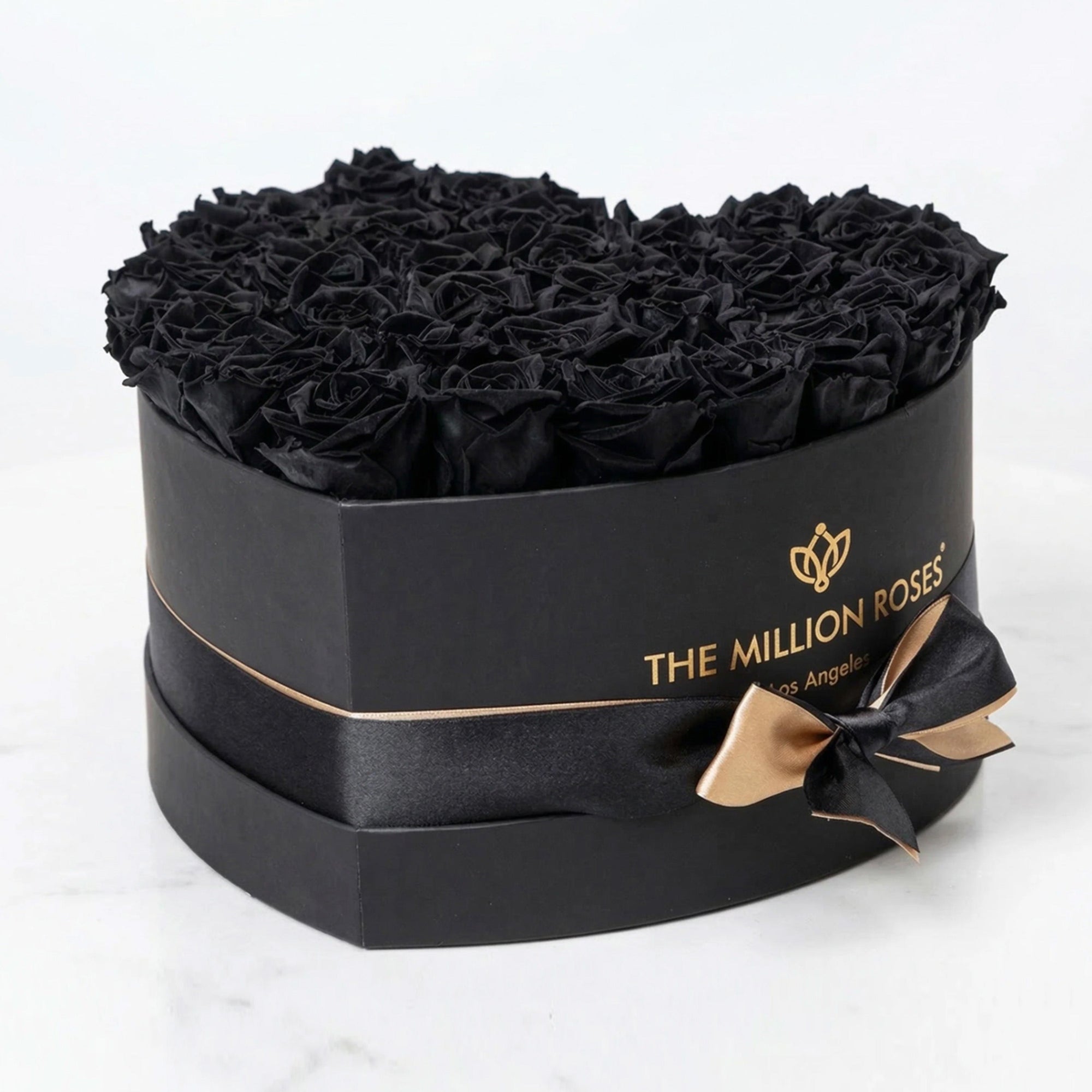 Black heart-shaped box filled with tightly arranged black roses from The Million Roses