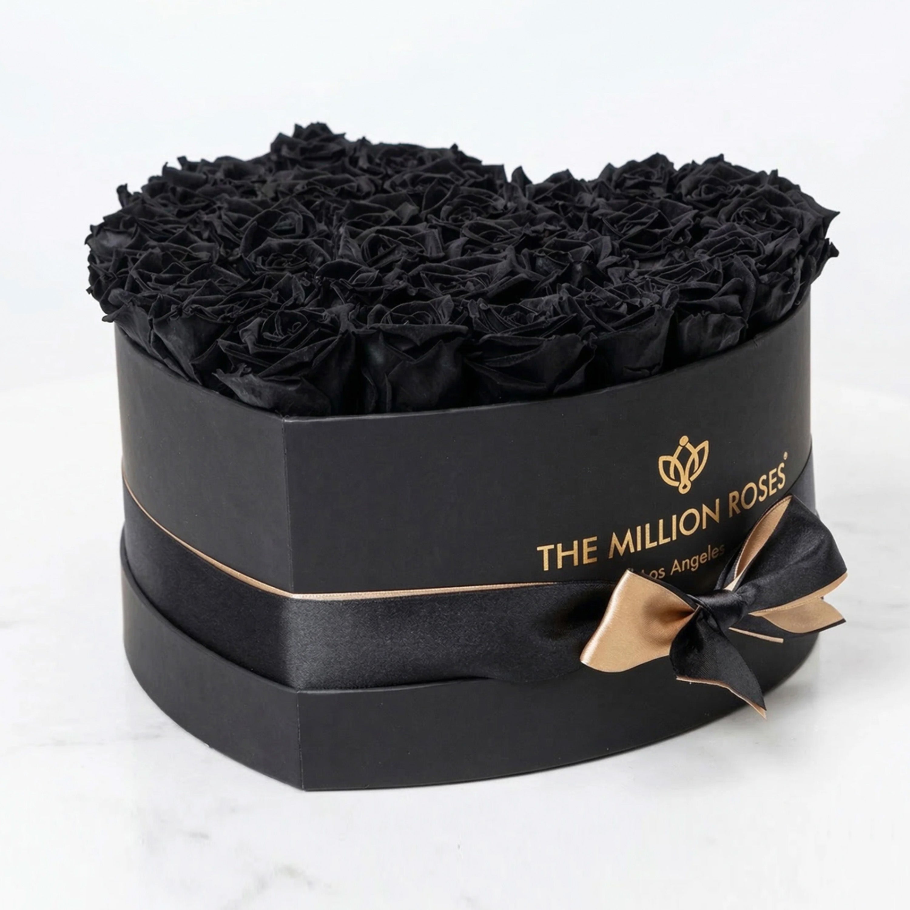 Black heart-shaped box filled with tightly arranged black roses from The Million Roses