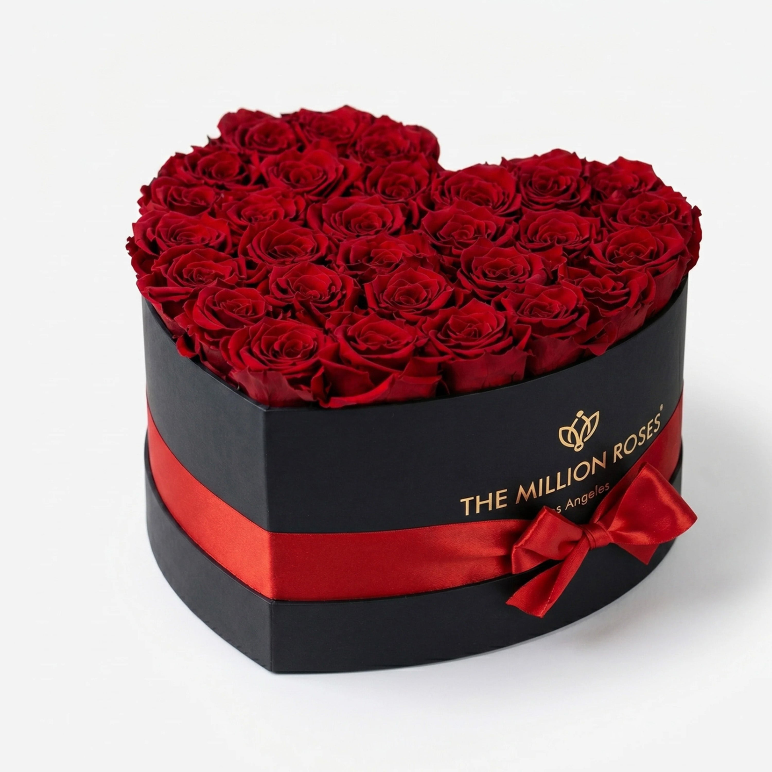 Heart-shaped black box filled with 28-30 brilliant red roses, arranged tightly and evenly.