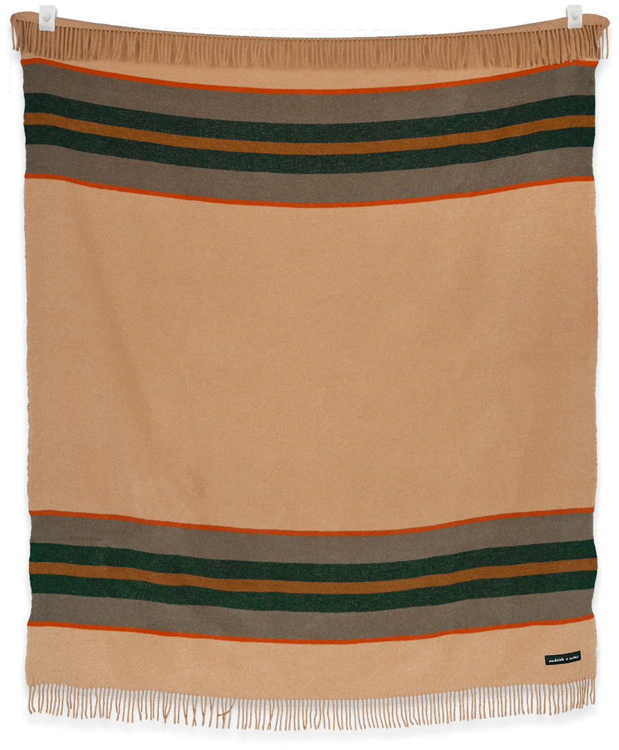 Camp Blaze blanket draped over a white sofa in a living room setting